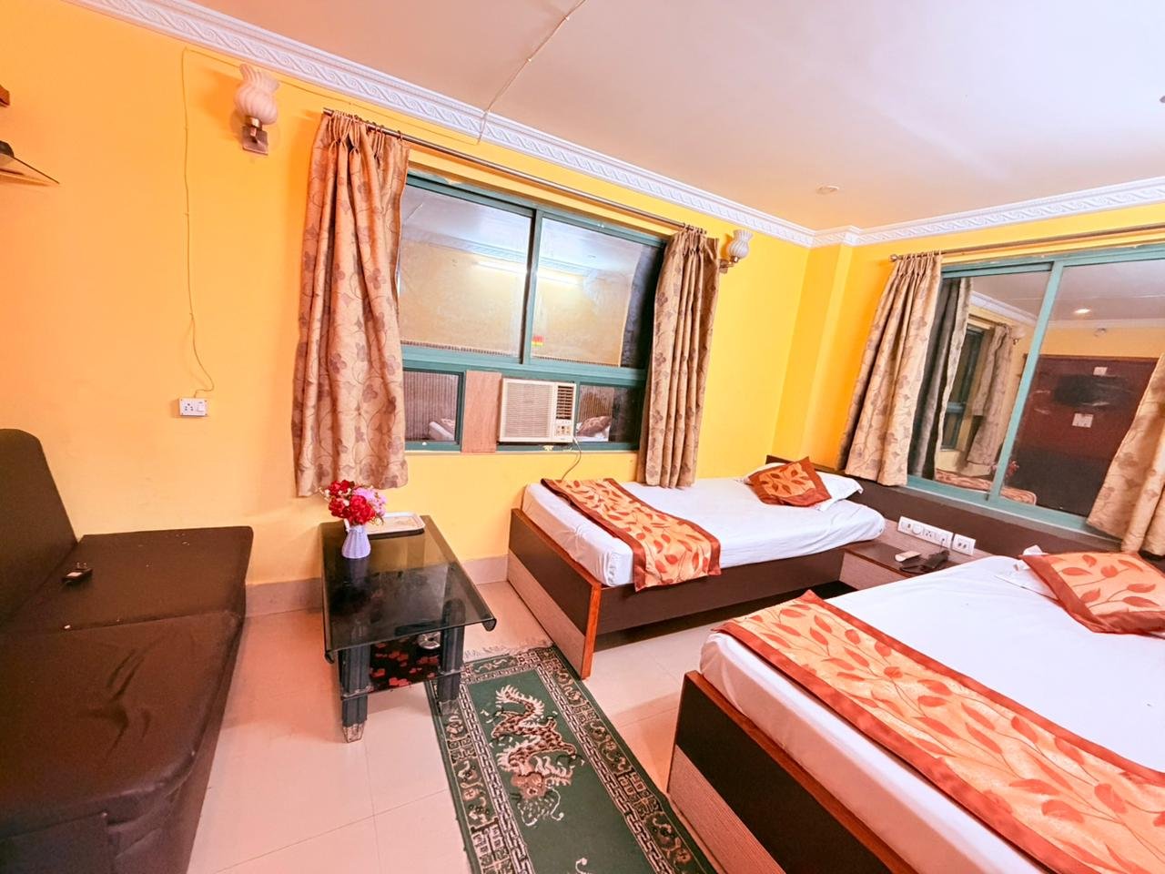 Spacious twin room with sofa, table and split AC