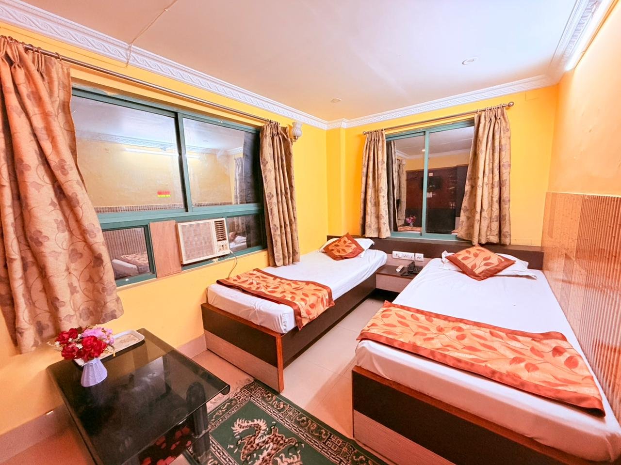 Twin-bed room with curtained windows and air conditioner